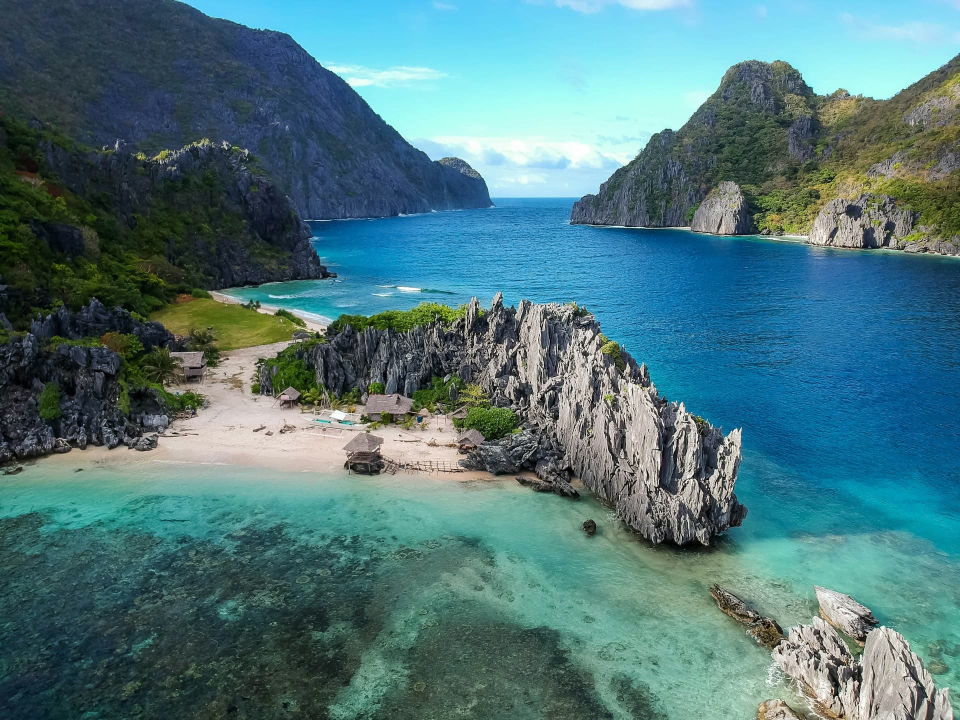 Turquoise water and white sand beach surrounded by limestone cliffs in the Philippines