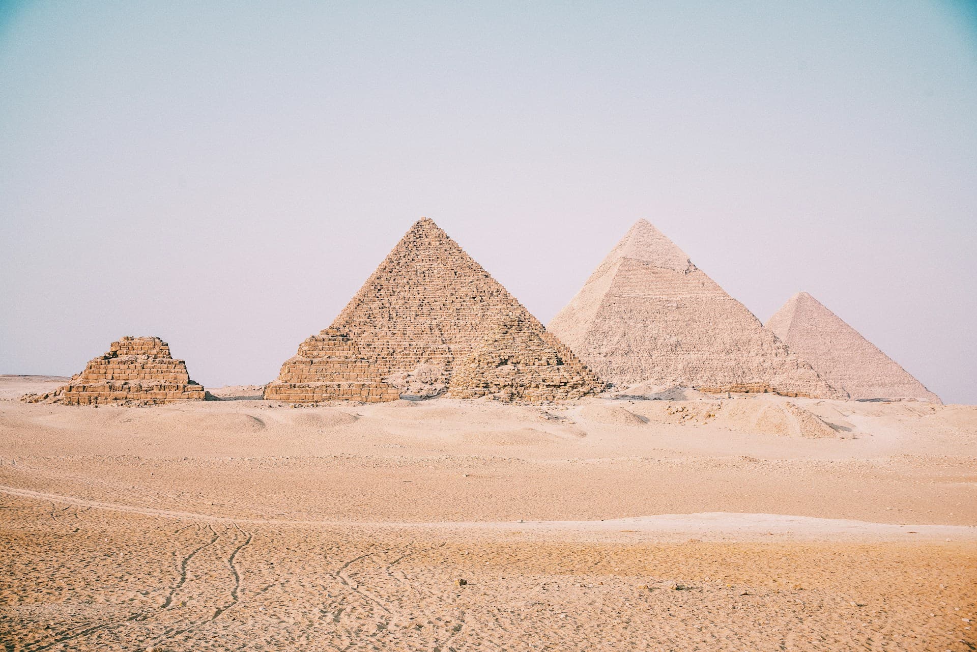 The Great Pyramids of Giza with camels in the foreground at sunset
