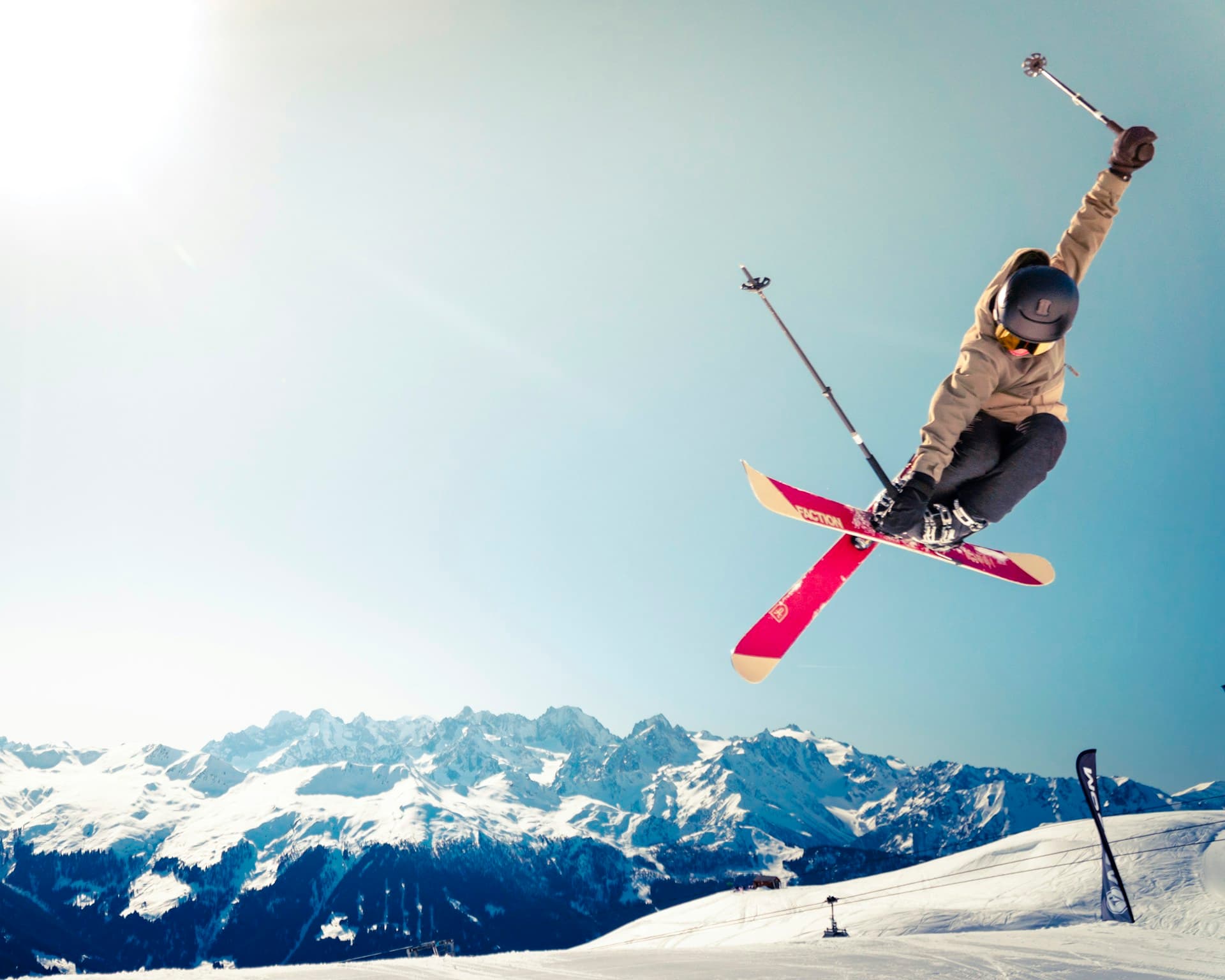 Skier carving through fresh powder on a sunny mountain slope