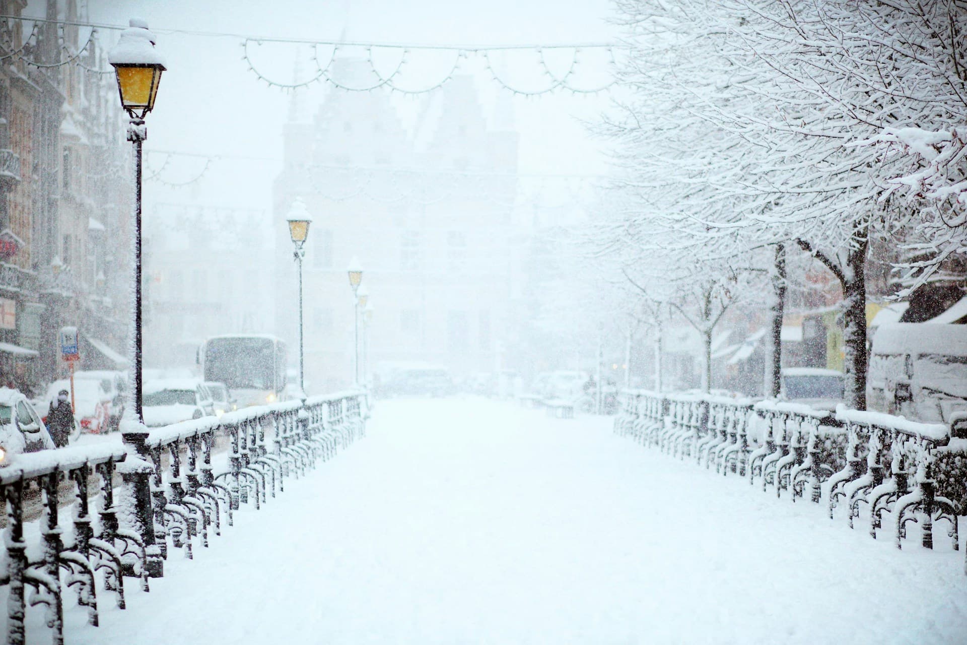 Person in warm layers walking through a snowy European city