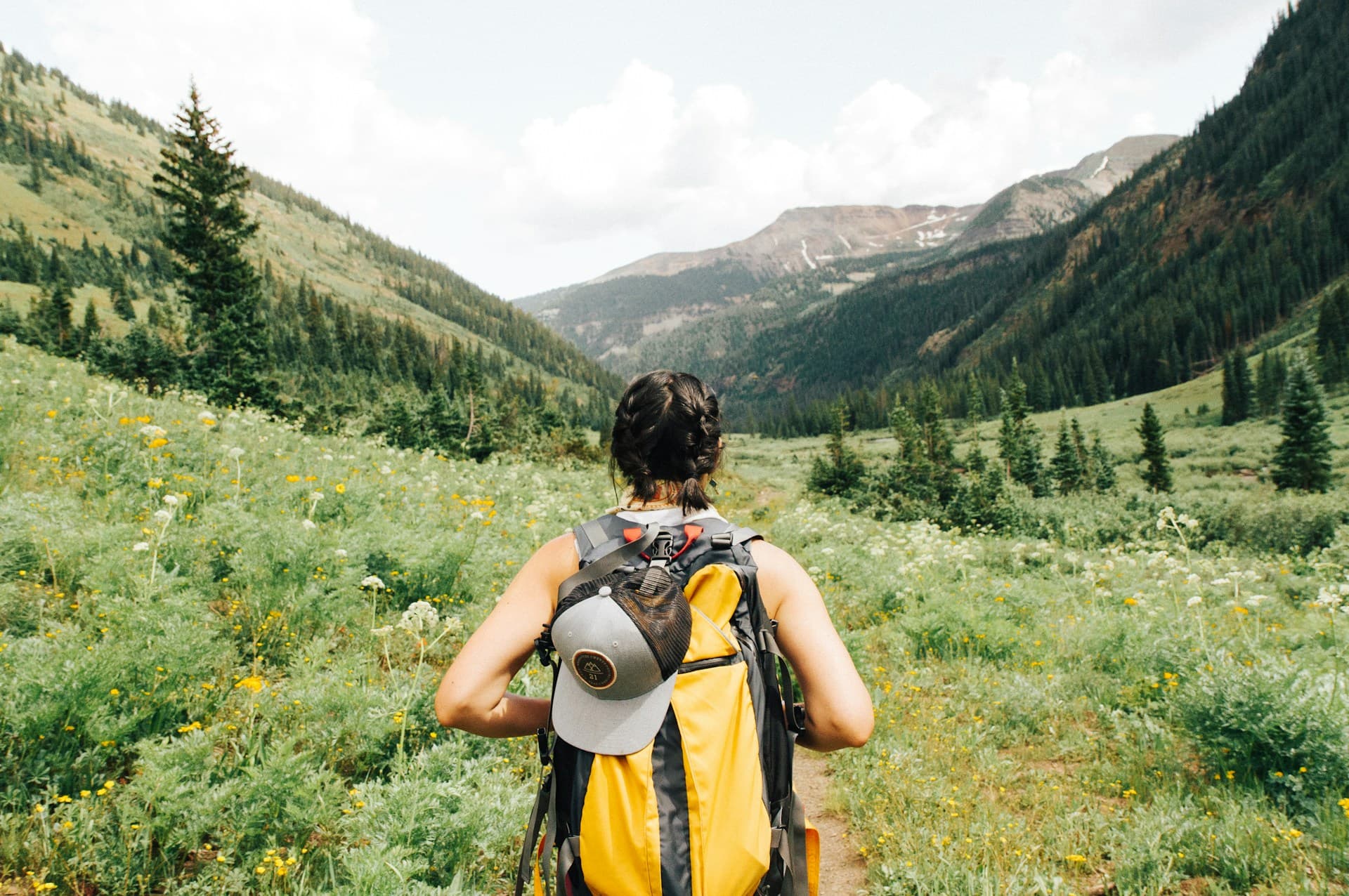 Backpacker walking along a scenic mountain road at sunrise